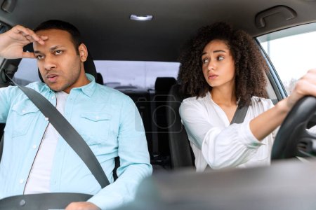 Photo for Stress And Conflicts On Road. Arabic Wife Driving Car And Looking At Angry Husband After Stressful Situation And Risk Of Crash. Woman Having Problems Learning To Drive With Displeased Instructor - Royalty Free Image