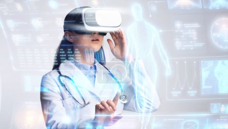 Foto de Futura tecnología médica, joven doctora profesional que usa gafas VR desarrollando tecnología para la curación personal, examinando los resultados de las pruebas de los pacientes en la interfaz holográfica, panorama - Imagen libre de derechos