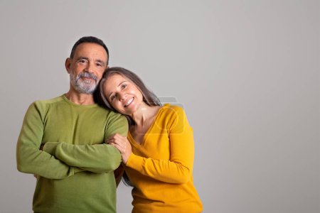 Cheerful european old husband and wife enjoy date together at spare time on gray studio background, free space. Family relationship, romance and positive, lifestyle, ad and offer