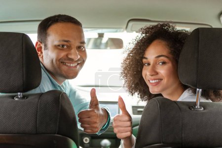 Photo for Great Road Trip. Cheerful Arabic Car Owners Couple Gesturing Thumbs Up Smiling To Camera Sitting On Front Seats In New Vehicle. Young Spouses Approving Their Newly Purchased Automobile - Royalty Free Image
