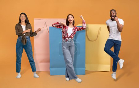 Photo for Concumerism concept. Cheery happy beautiful multiethnic young people man and women in casual posing by big shopping bags over colorful background, collage. Shopaholics enjoying season sale - Royalty Free Image