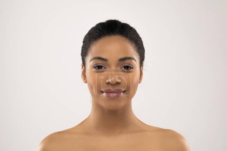 Photo for Beautiful millennial african american woman posing half-naked on colorful grey studio background, smiling at camera, showing glowing perfect young skin, closeup, copy space - Royalty Free Image