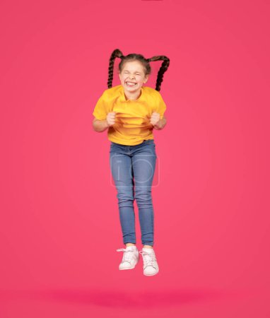 Photo for Cheerful Preteen Girl With Braids Hairstyle Jumping In Air On Pink Background, In Motion Shot Of Joyful Caucasian Female Child Fooling And Having Fun Over Pink Background, Full Length, Copy Space - Royalty Free Image