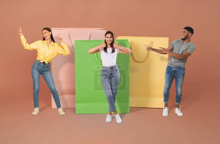 Photo for Concumerism concept. Positive beautiful multiethnic millennial people man and women in casual posing by big shopping bags over colorful background, collage. Shopaholics enjoying black friday sale - Royalty Free Image