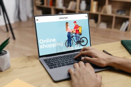 Photo for Black man using laptop for online shopping, buying clothes in fashion store, shopping from home. Order delivery, sale for shopaholic, app and website for new clothes - Royalty Free Image