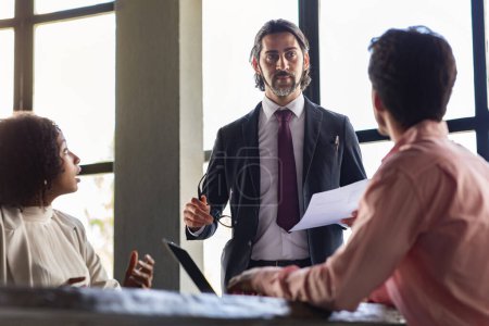 Photo for International management team have meeting at conference hall at office, middle aged man in formal outfit CEO manager give instructions to leaders, employees using laptops, have discussion - Royalty Free Image