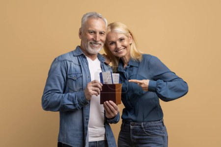 Photo for Tourism tourists traveler journey rest weekend vacation holiday relax concept. Photo portrait of excited elderly man and woman friends couple showing document with tickets isolated beige background - Royalty Free Image