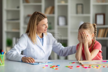 Photo for Cognitive Behavior Therapy. Psychotherapist Lady Comforting Crying Female Child During Meeting In Office, Upset Little Girl Covering Face With Hands, Having Mental Breakdown, Closeup - Royalty Free Image