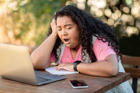 Photo for Boring E-Learning. Bored Hispanic Student Lady Yawning Sitting At Laptop During Online Studies Outdoors, Side View Shot. Sleepy Learner Posing Tired Of Uninteresting Lessons At Computer - Royalty Free Image