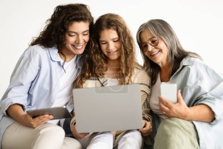 Photo for Smiling european old, adult and teen woman with smartphone, tablet and laptop have video call, isolated on white wall background, studio. Device, app social networks, family relationships - Royalty Free Image