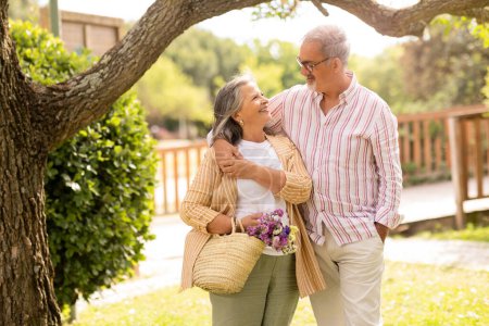 Photo for Positive old european husband hugging wife, enjoy walk together in park, holiday in city, outdoor. Relationships, romantic date, lifestyle and weekends, free time with family - Royalty Free Image