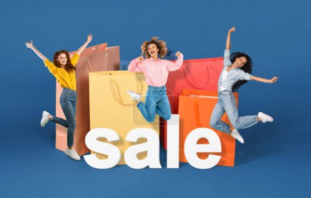 Photo for Consumerism. Three women on shopping jumping near large shopper bags and word sale, advertising discount commercial offer over blue studio background. Shopaholics celebating black friday. Collage - Royalty Free Image