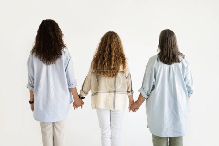 Photo for Senior, millennial women and teen girl holding hands, isolated on white studio background, back. Family love, female generation, relationship mom, grandmother and daughter, ad, offer - Royalty Free Image