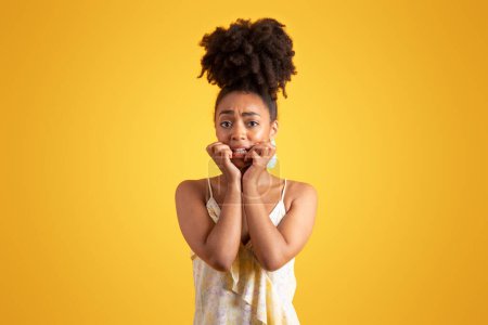 Photo for Shocked scared worried pretty millennial african american lady presses her hands to face, isolated on yellow background, studio. Fear, waiting bad news, reaction, ad and offer - Royalty Free Image