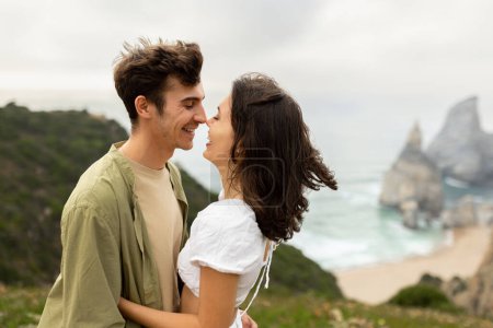 Photo for Coastal connection. Happy young couple embracing and bonding, enjoying date on coastline, with perfect view at ocean shore, copy space - Royalty Free Image
