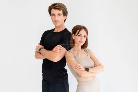 Photo for Serious confident millennial european guy and lady in sportswear with fitness tracker crossed hands on chest, isolated on gray background. Workout, body care, active lifestyle and sports together - Royalty Free Image