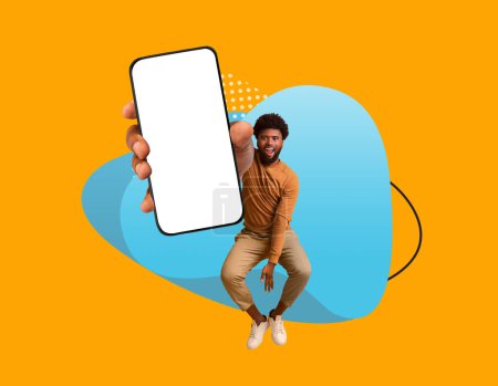 Photo for Mobile Ad. Cheerful Black Man Demonstrating Big Smartphone With Blank Screen, Happy Young African American Guy Showing Empty Cellphone While Jumoing Over Colorful Abstract Background, Mockup - Royalty Free Image