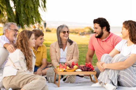 Photo for Glad caucasian multi-generation people relax outdoor, enjoy picnic, food and weekend in park. Love, meeting together, summer holidays, family relationship and communication - Royalty Free Image