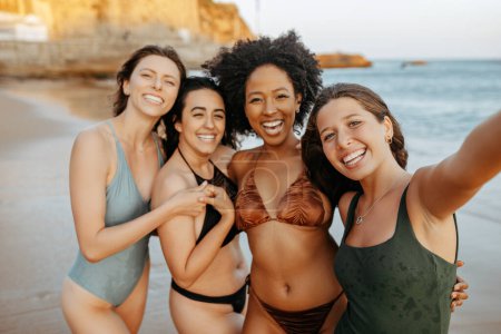 Foto de Selfie de verano, playa y diversas amigas disfrutando de vacaciones, vacaciones y fin de semana juntas. Grupo de damas sonriendo, tomando fotos para las redes sociales - Imagen libre de derechos