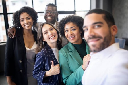 Photo for Successful Business Team. Happy Multiethnic Colleagues Businessmen And Businesswomen Making Group Selfie Smiling At Camera, Posing Together In Modern Office Indoors. Selective Focus - Royalty Free Image