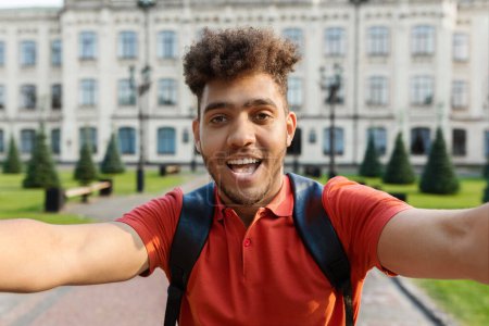 Photo for Closeup Shot Of Handsome Young Male Student Taking Selfie Outdoors, Happy Freshman Guy Wearing Backpack Posing Outside Against College Building, Looking And Smiling At Camera, Free Space - Royalty Free Image