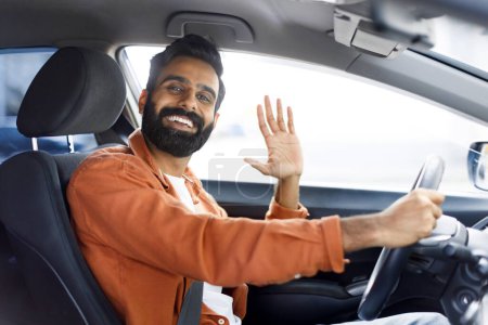 Photo for New Car. Cheerful Indian Man Waving Hand Gesturing Hi From Drivers Seat, Posing In Modern Auto Inside, Smiling At Camera. Great Automobile Sale, Dealership Offer Concept - Royalty Free Image