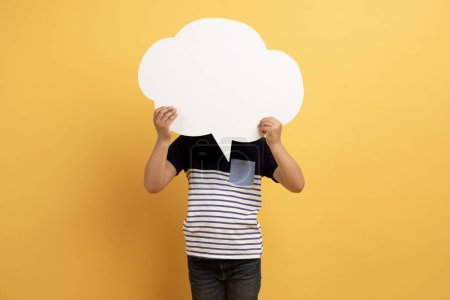 Photo for Kids opinion matters concept. Preteen child boy wearing casual outfit holding empty white communication bubble over his head, posing on yellow background, schooler expressing his feelings, desires - Royalty Free Image