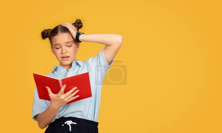 Téléchargez les photos : Malheureux fatigué caucasien adolescent fille lecture livre, met la main à la tête, souffrir de devoirs, isolé sur fond de studio orange. Problèmes d'études, d'éducation à l'école, de stress et d'émotions - en image libre de droit
