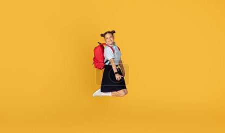 Photo for Happy caucasian teenager girl pupil with backpack jumping, freeze in air, celebrating victory, have fun, enjoy education, isolated on orange studio background. Study at school, ad and offer, sale - Royalty Free Image