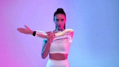 Photo for Sports and technology concept. Sports tech. Health care technology. Fit lady in white fitwear stretching arms wearing smart fitness watch exercising on neon background. Sport motivation, panorama - Royalty Free Image
