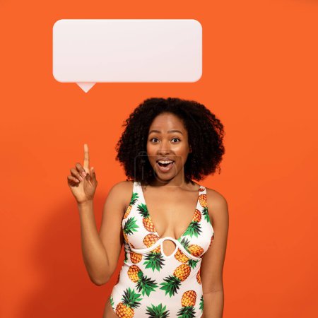 Photo for Excited beautiful young african american lady enjoying weekend, wear colorful tropic suit brassiere, orange background, raising finger up at empty communication bubble, have nice ideas for vacation - Royalty Free Image