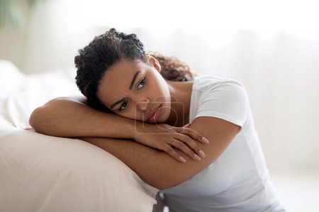 Photo for Portrait Of Upset Black Woman Leaning On Bed In Bedroom At Home, Depressed Young African American Female Suffering Life Problems Or Mental Breakdown, Brokenhearted Lady Feeling Lonely, Closeup - Royalty Free Image