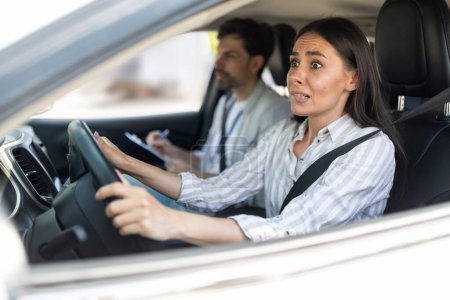 Photo for Scared unconfident young woman driving car with instructor man by her side. Lady driving school student passing exams test, looking at road with frightened face expression. Fear of driving - Royalty Free Image