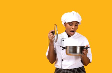 Photo for Cooking Failure. Shocked Black Chef Woman Looking Into Saucepan, Surprised African American Cook Female Made Untasty Meal, Standing Isolated Over Yellow Studio Background, Copy Space - Royalty Free Image