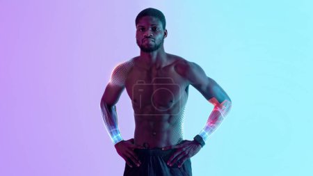 Photo for Digital sports concept. Handsome athletic young African american sportsman with naked torso and futuristic hologram on his arms posing in neon light, panorama with copy space, collage - Royalty Free Image