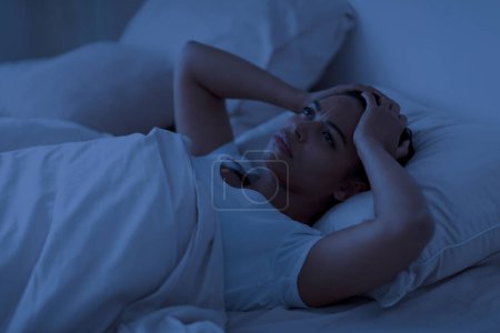 Téléchargez les photos : Problème de sommeil. Femme afro-américaine stressée couchée seule au lit et touchant la tête, jeune femme noire éveillée la nuit, déprimée, souffrant d'insomnie ou de problèmes mentaux - en image libre de droit