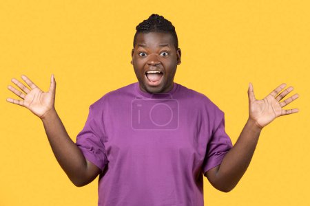 Téléchargez les photos : Wow Offre. Homme noir excité criant OMG regardant la caméra dans l'excitation, gesticulant avec les mains, exprimant joie et surprise sur les nouvelles étonnantes sur fond jaune studio, Portrait Shot - en image libre de droit