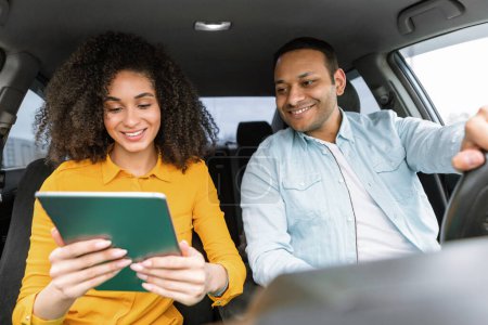 Foto de Pareja de la familia de Oriente Medio en el coche utiliza la aplicación de navegación en la tableta digital, Navegando por el camino con navegación GPS en línea, Disfrutando del paseo en automóvil y la tecnología informática - Imagen libre de derechos