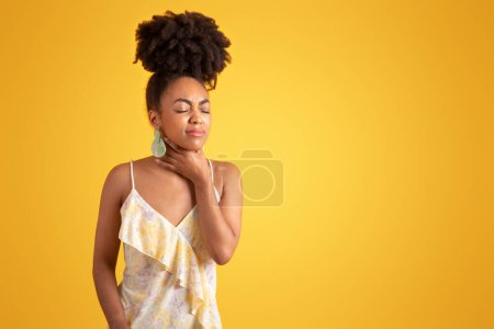 Photo for Unhappy millennial black woman presses hands to throat, suffering from pain, flu and cold, isolated on orange background, studio. Sore throat, health problems, human emotions, disease symptoms - Royalty Free Image