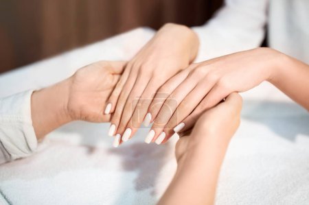 Photo for Perfect Manicure. Closeup Of Manicured Female Hands At Nail Studio, Professional Manicurist Master Looking At Result Of Her Work, Cropped Shot. Nails Spa And Beauty Care Concept - Royalty Free Image
