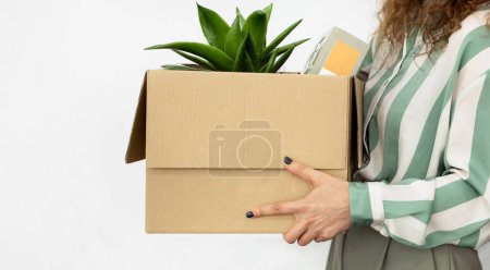 Photo for Career Start. Unrecognizable employee lady carrying cardboard box with belongings on white background, cropped. Businesswoman going on new job, symbol of workplace change or termination. Panorama - Royalty Free Image