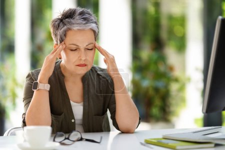 Photo for Tired exhausted middle aged woman employee sitting at workplace with closed eyes at home office, rubbing temples. Overworked mature lady suffering from migraine, have headache. Burnout concept - Royalty Free Image