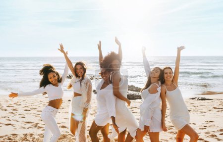 Foto de Fiesta de despedida de soltera. Grupo de amigas bailando en la playa en un día soleado, divirtiéndose y disfrutando de despedida de soltera en la orilla del océano, espacio libre - Imagen libre de derechos