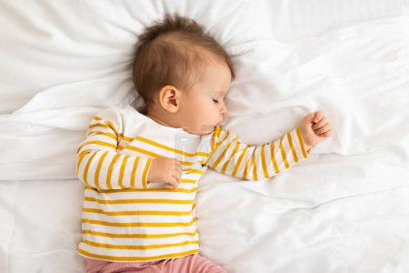Photo for Adorable little baby girl sleeping on white bedding, feeling safe, watching sweet dreams, growing, gaining strength, top view, copy space. Peaceful child napping during daytime sleep - Royalty Free Image