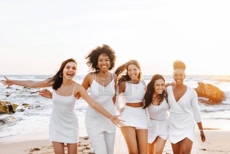 Photo for Excited multiracial ladies having fun on the beach, smiling cheerfully at camera while enjoying hen party celebration on coastline in the evening, free space - Royalty Free Image