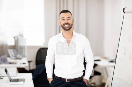 Photo for Glad confident caucasian mature guy with beard in white shirt in coworking office interior. Successful business, businessman work, teacher and study, boss, manager, lifestyle - Royalty Free Image