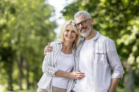 Photo for Portrait Of Loving Senior Couple Embracing Outdoors And Smiling At Camera, Romantic Mature Spouses Hugging While Posing Together Outside, Older Man And Woman Bonding While Walking In Summer Park - Royalty Free Image