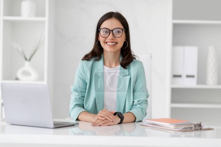 Photo for Businesswoman lifestyle. Happy millennial european lady in glasses uses computer, enjoy work in white office interior. Teacher, manager and app for business, startup and technology - Royalty Free Image