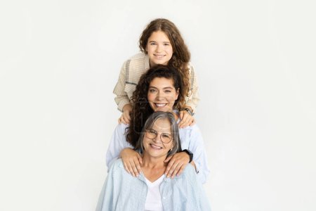 Photo for Glad happy caucasian adult mom, teen girl and old grandmother have fun, isolated on white studio background. Spare time, female generation, relationship and family, ad, offer - Royalty Free Image