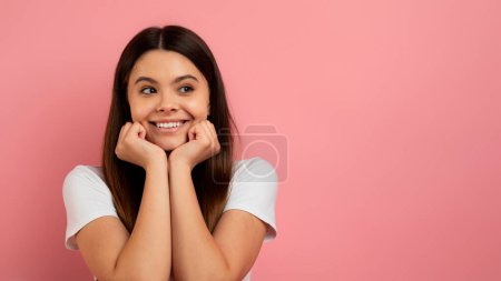 Photo for Excited Teen Girl Touching Face And Looking At Copy Space With Amazement, Happy Cute Female Teenager Emotionally Reacting To Amazing Offer Or Sale, Standing On Pink Background, Panorama - Royalty Free Image